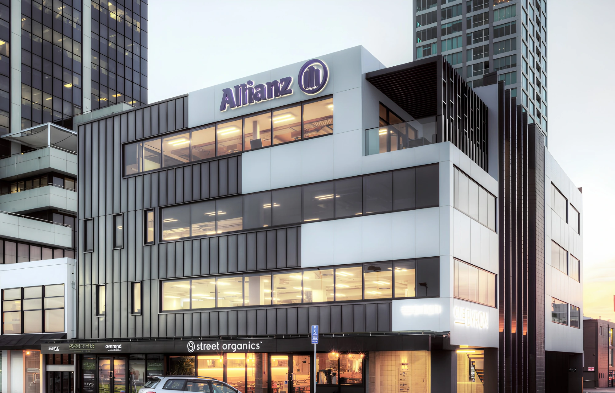 Commercial building with illuminated offices and street-level shops at dusk
